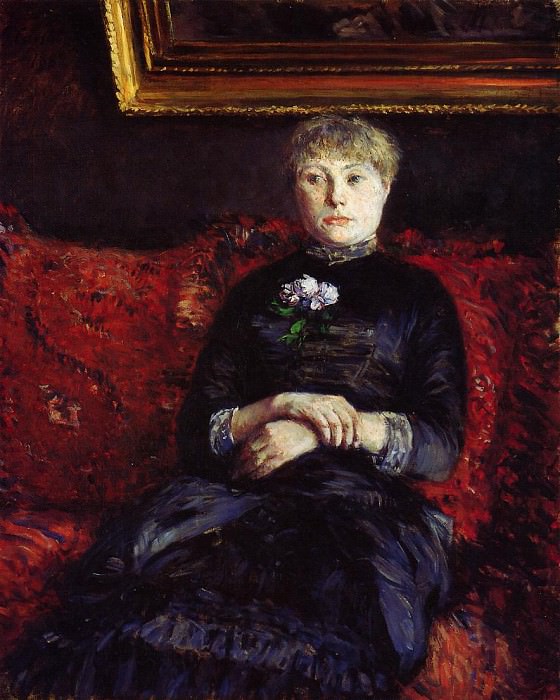 Женщина, сидящая на красной в цветочках софе картина